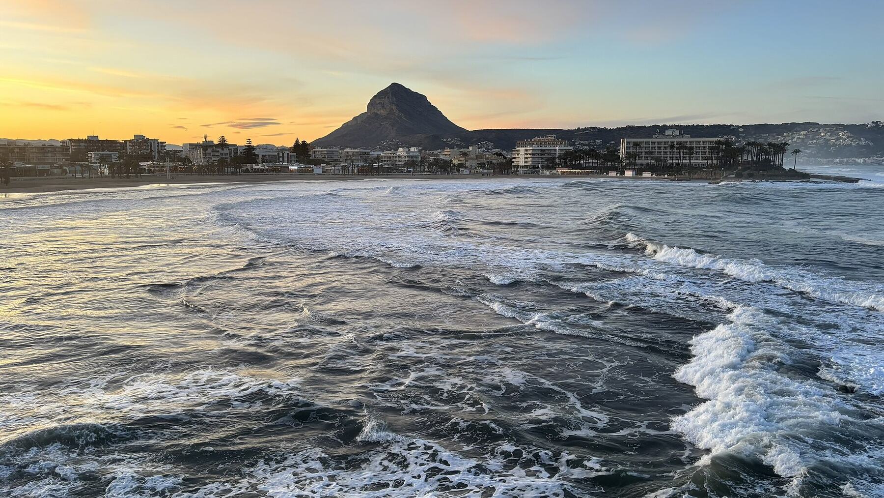Strand El Arenal in Jávea bei Sonnenuntergang, dahinter der Montgó
